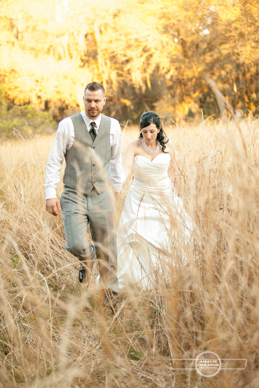 bride and groom in field walking