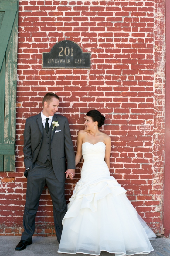 Bride and groom on brick wall